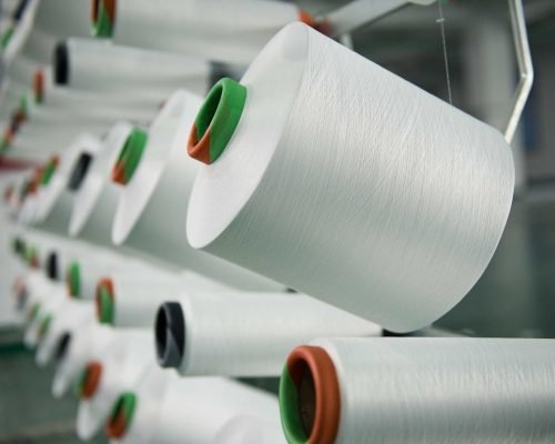 textile industry Textile industry - yarn spools on spinning machine in a textile factory